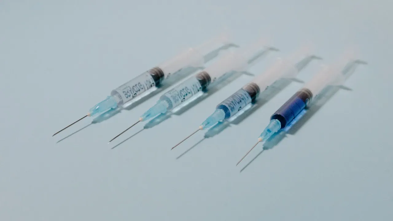 A collection of sterile syringes arranged on a blue surface, ideal for medical themes.