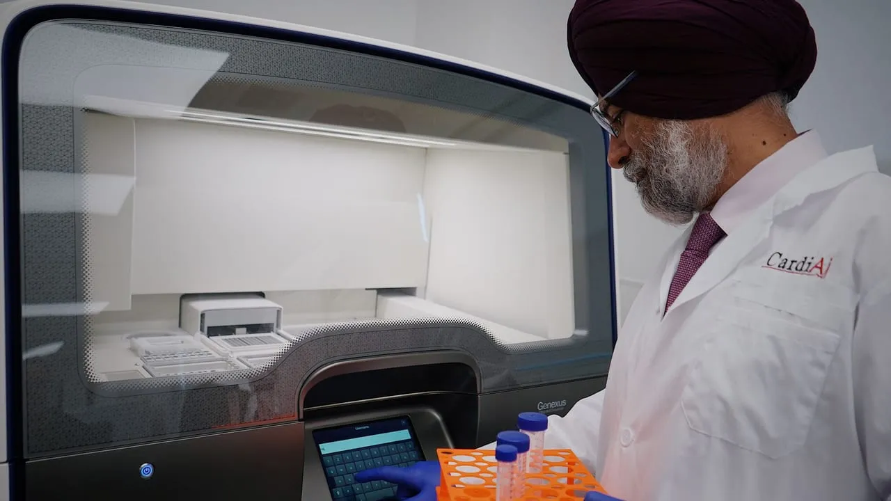 Researcher in lab analyzing samples with high-tech equipment. Wearing protective lab gear.