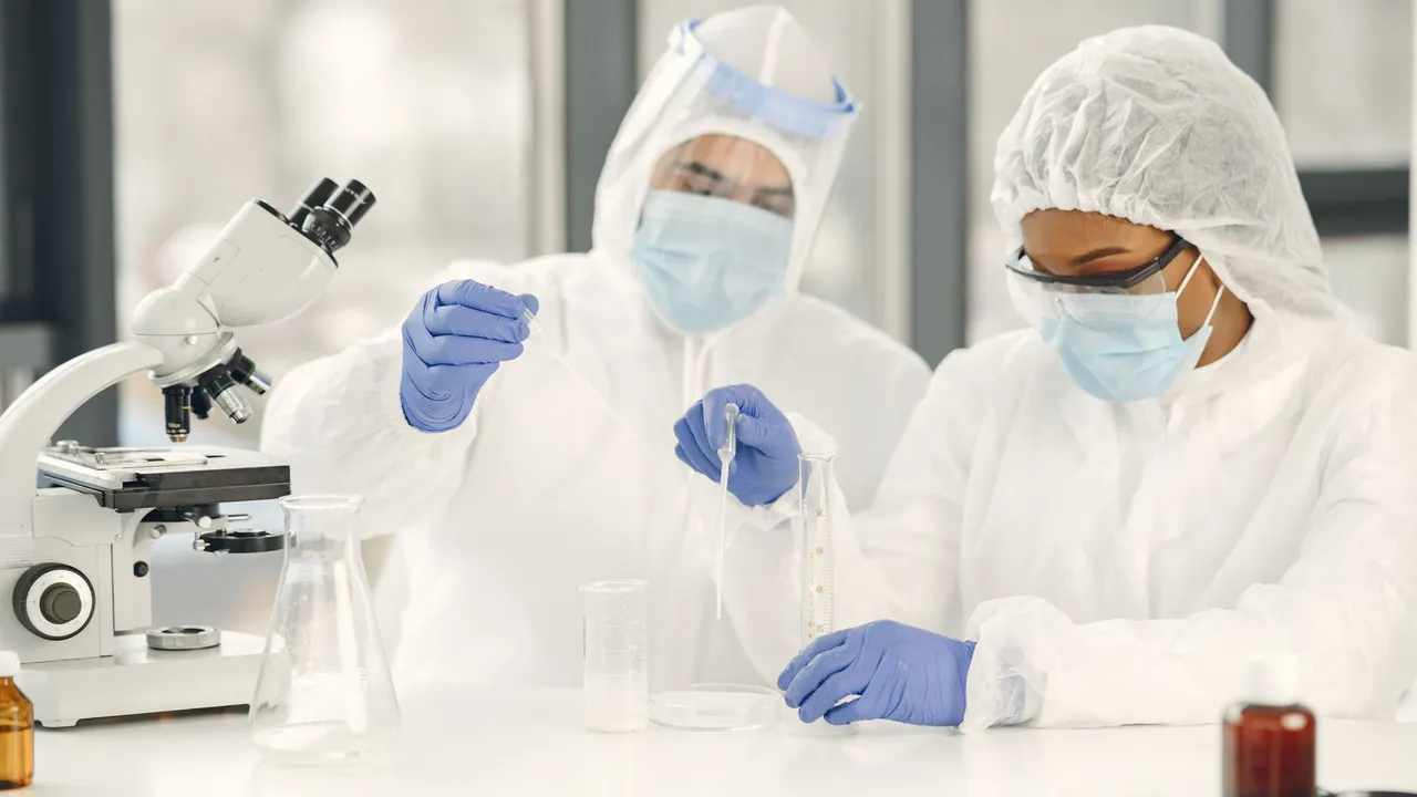 A female scientist wearing a lab coat uses a microscope for research in a laboratory setting.