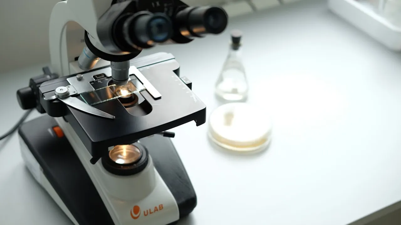 A microscope sitting on top of a table next to a bottle