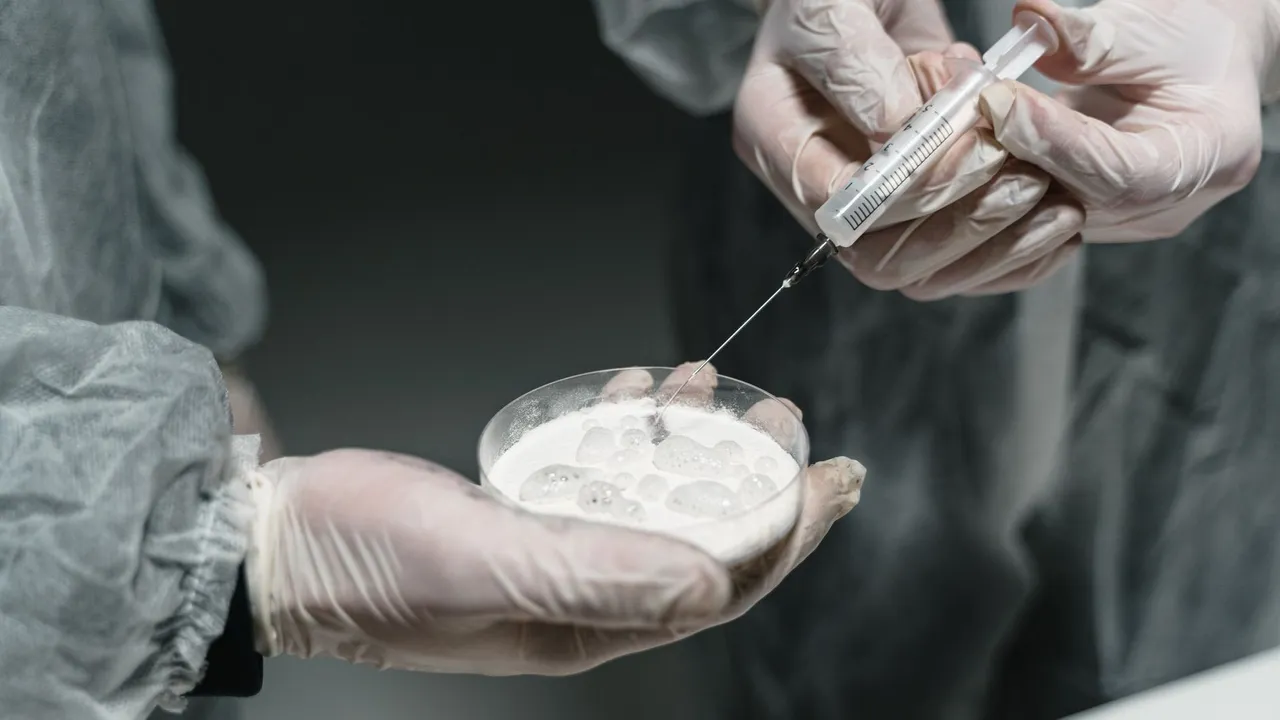 Researchers conducting a scientific experiment with a syringe and petri dish in a lab setting.