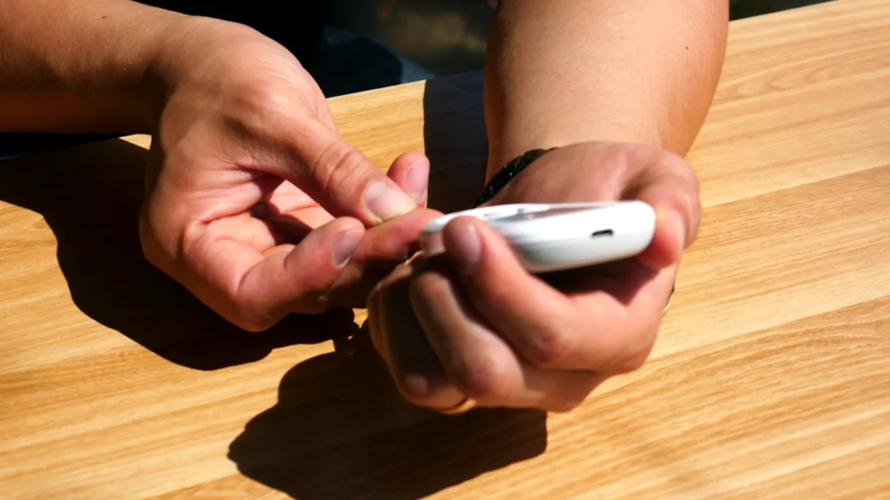 a person sitting at a table with a cell phone